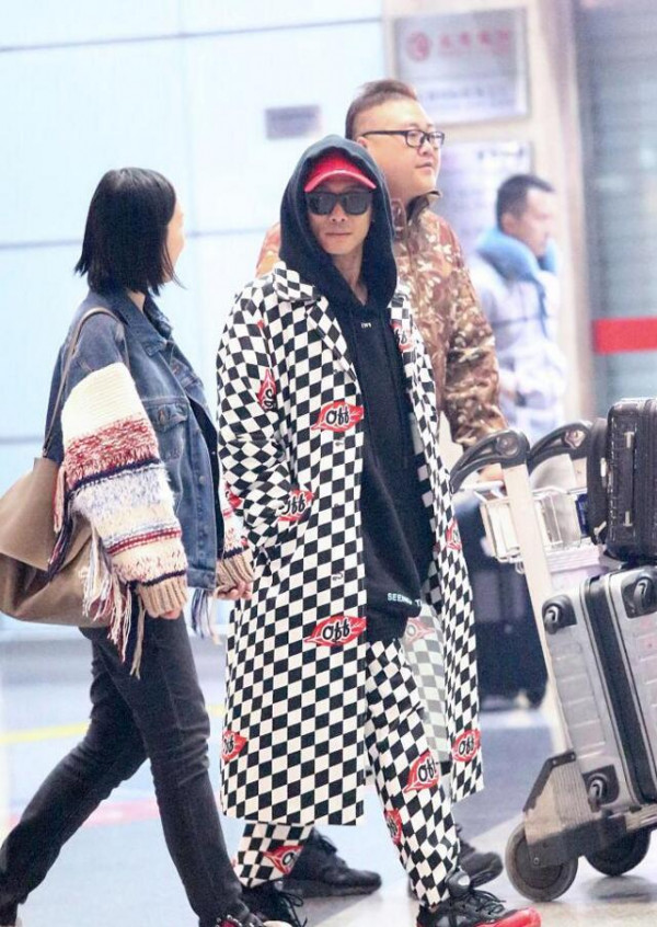 行走的棋盘格!55岁杜德伟穿潮装与女助理热聊机场扎眼